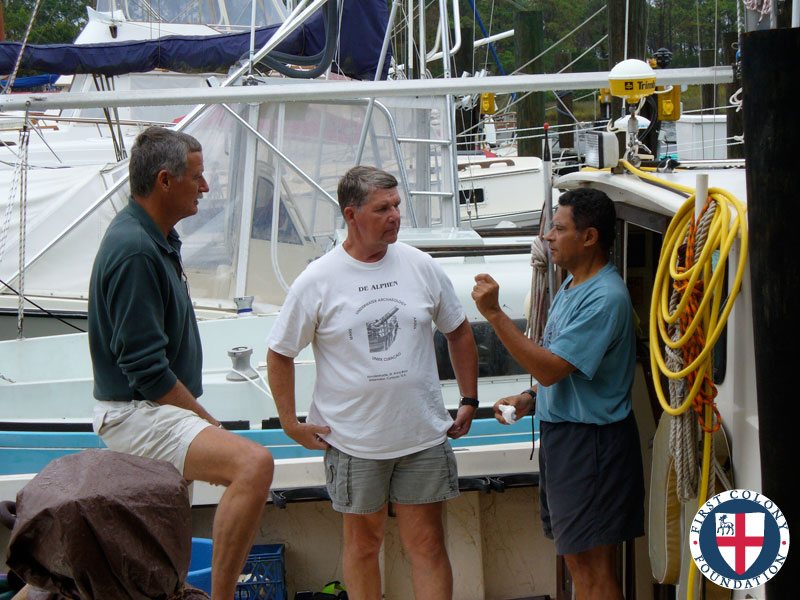 Gordon Watts consults with team members Bill Utley and Ray Hayes on underwater survey work (left to right)