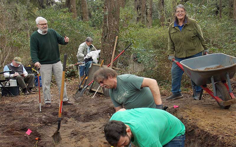 Eric Klingelhofer directs volunteers Jeremy Bliven (foreground) and Jay Ward, as digging begins, while Tama Creef looks on.